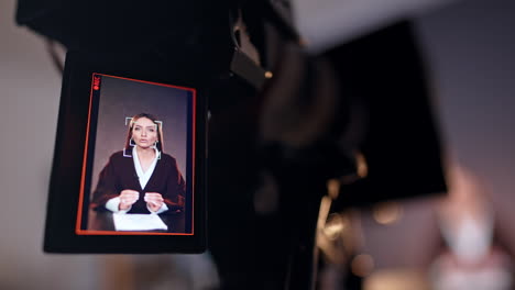display of a modern camera showing a lady talking and gesturing. close up. blurred backdrop.