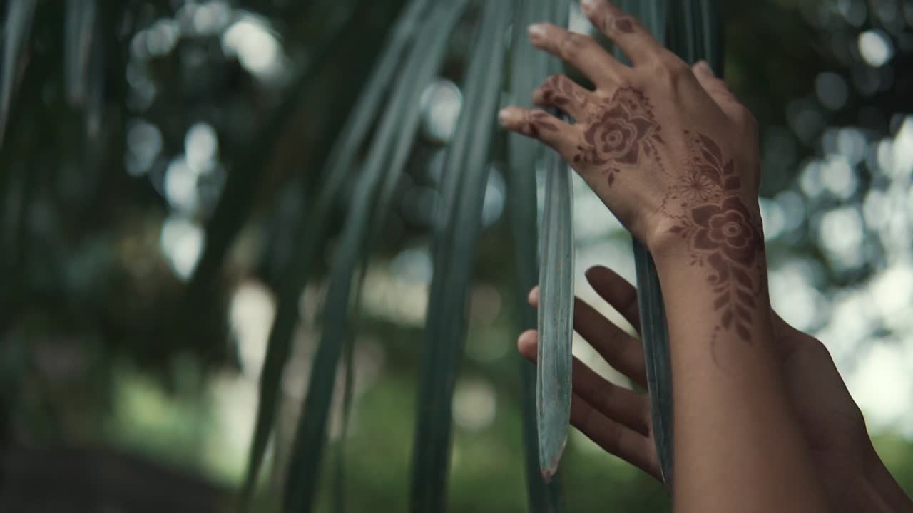 Tatuaggio all'henné sulle mani con foglie di palma