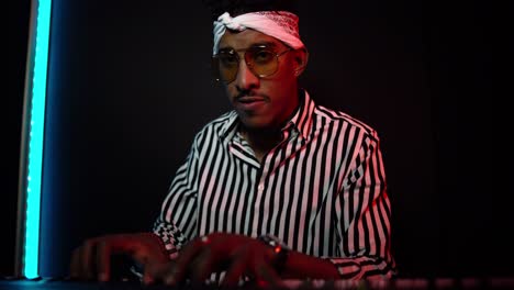 Black-man-playing-synthesizer-in-studio