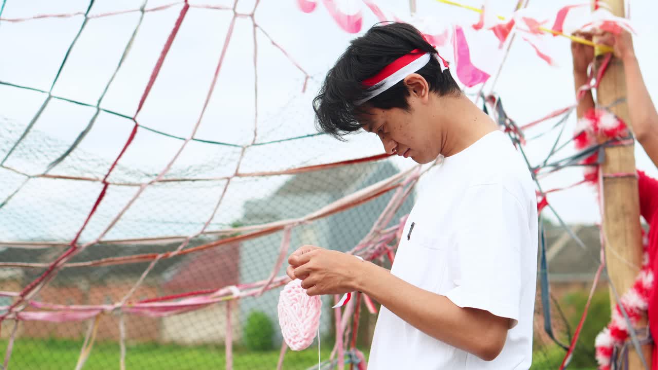 Young Indonesian Men Collaborate To Set Up Decorations And The Cracker Eating Game for Independence Day Celebrations
