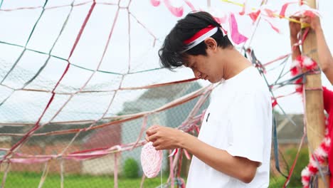 young indonesian men collaborate to set up decorations and the cracker eating game for independence day celebrations