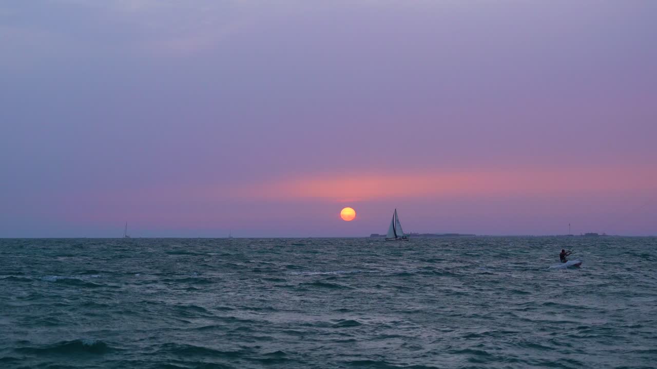 카이트 서퍼와 세일 보트는 두바이의 유명한 카이트 해변에서 여가를 즐깁니다.