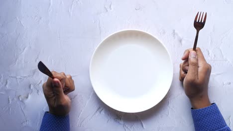 Cutlery-and-empty-plate-on-wooden-background