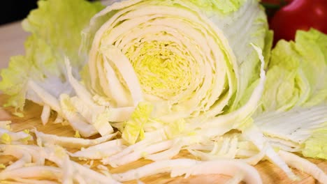 hands slicing cabbage on a wooden board