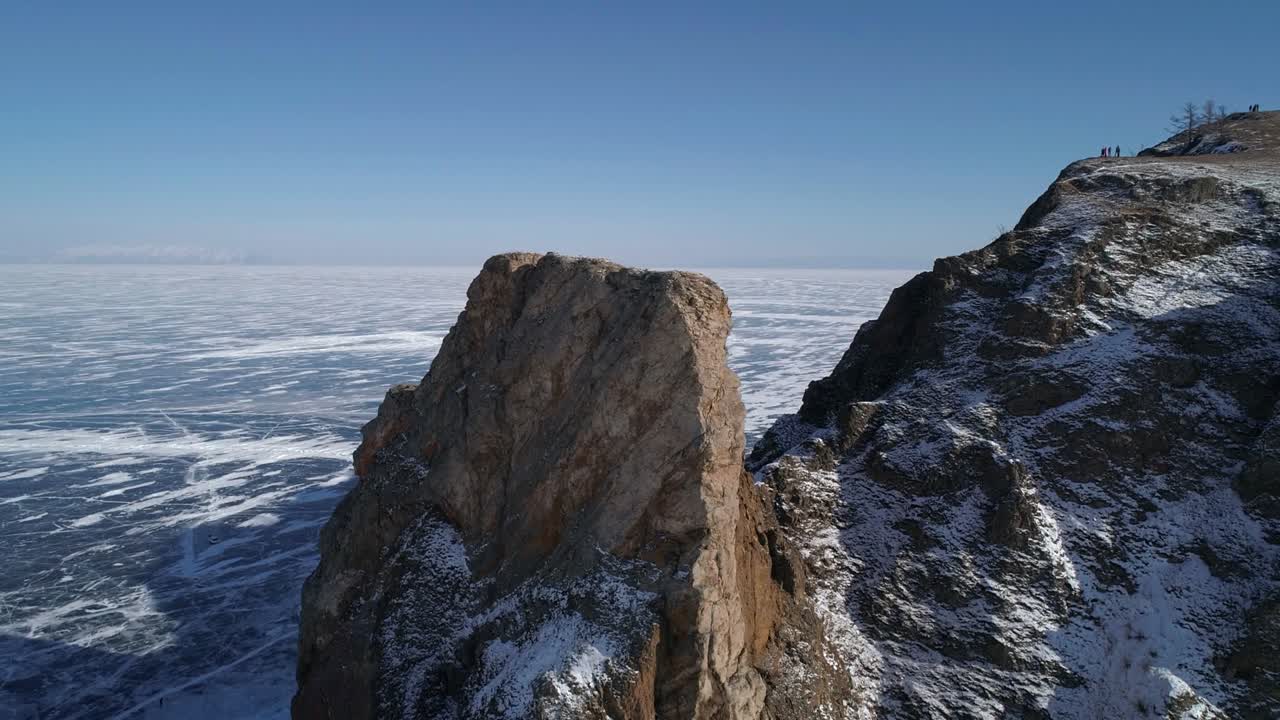 tomada orbital aérea del cabo khoboy, isla de olkhon. rocas altas en el lago congelado baikal. destino turístico popular. paisaje de invierno. vista panorámica