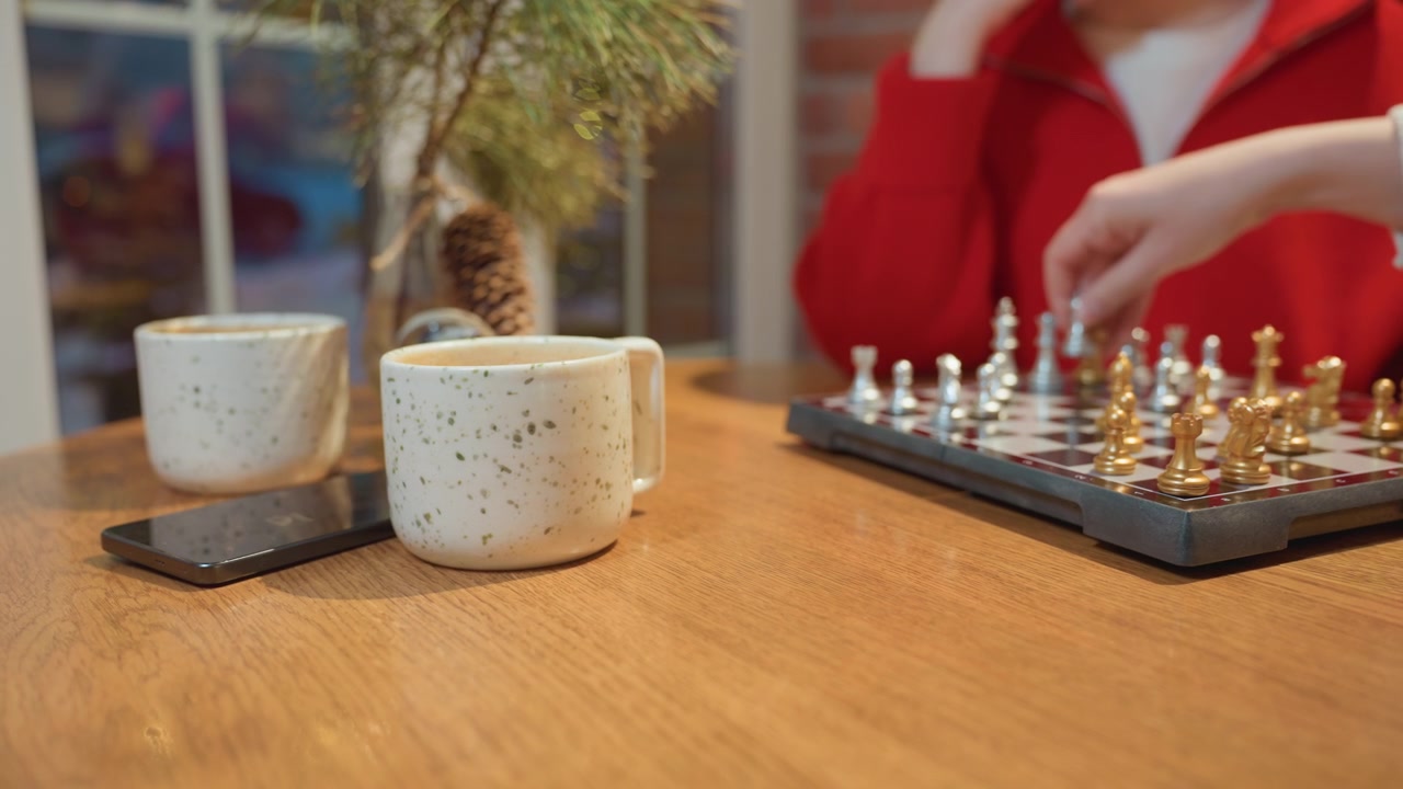 Nærbilde av hender som spiller sjakk på et trebord
