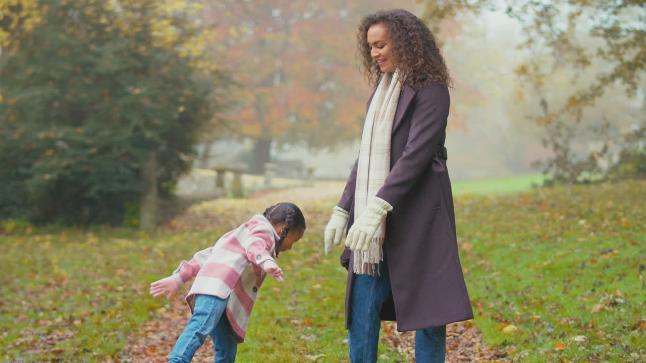 madre e hija divirtiéndose en una caminata en el campo de otoño equilibrándose en una pierna