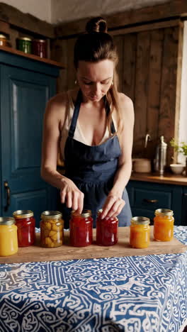 woman preparing homemade jams and fruit preserves in the kitchen