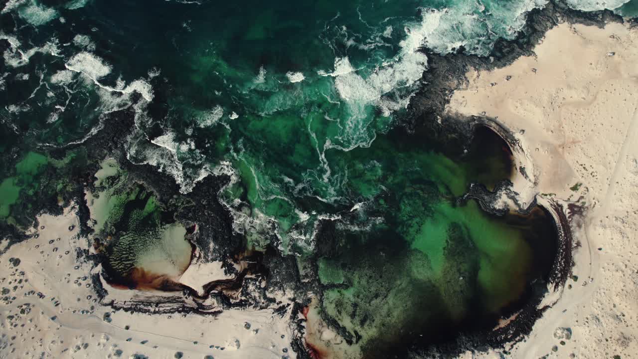 Aerial view of turquoise tide filling rocky tidal pools
