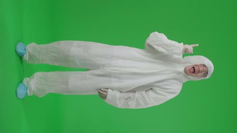 full body of asian man wearing personal protective equipment uniform ppe and thinking about something and looking around then raising his index finger in the green screen studio