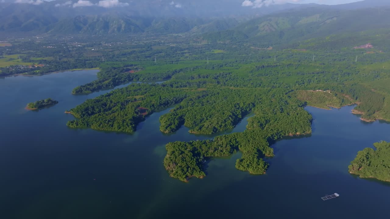 Rincon Dam reservoir with lush tropical vegetation and winding waterways, Dominican Republic. Ideal for travel and nature content. Aerial drone descending