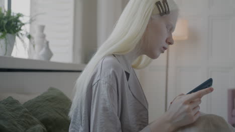 una adolescente usando un teléfono inteligente en el dormitorio
