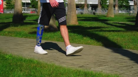 man with prosthetic leg walking in a park