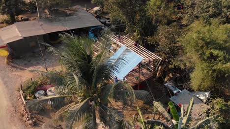 clip en movimiento de lado a vista frontal de los trabajadores colocando el techo de un edificio inacabado en battambang, camboya