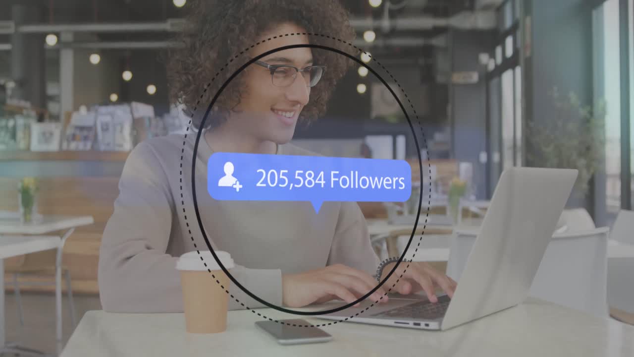 animación del icono del perfil con números crecientes sobre hombre biracial usando portátil en una cafetería.