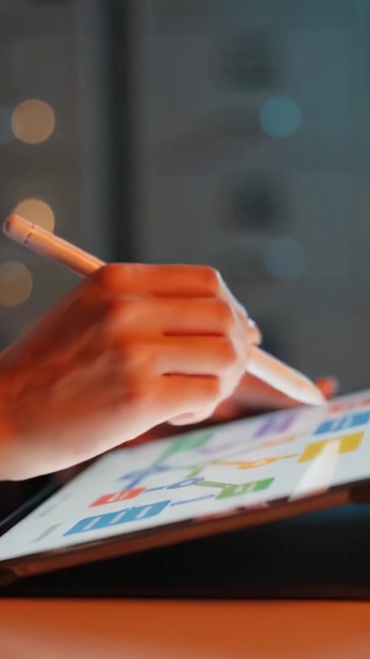 Interagire con strumenti digitali: un primo piano sulle mani che usano uno stilo su un tablet che mostra grafici e diagrammi colorati in un ambiente di lavoro moderno.