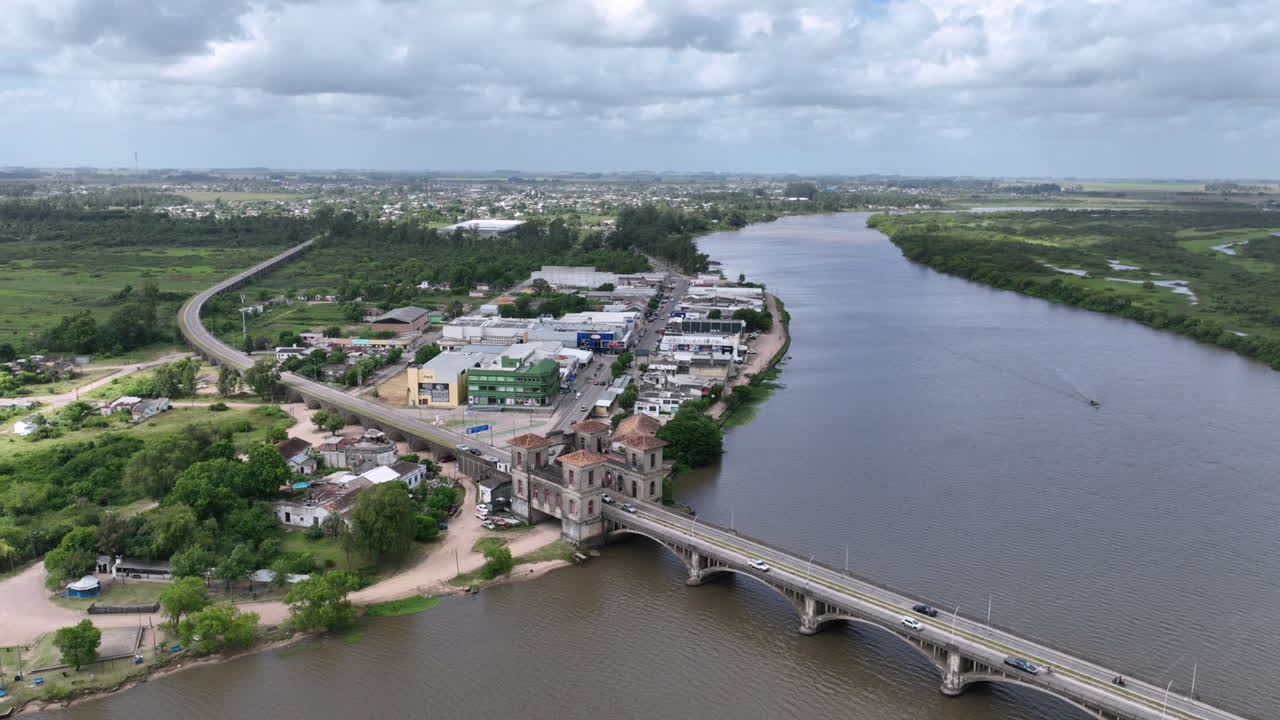 Panoramica aerea cinematografica della costa di Rio Branco in Uruguay e del suo collegamento con lo storico ponte internazionale Maua al confine con il Brasile
