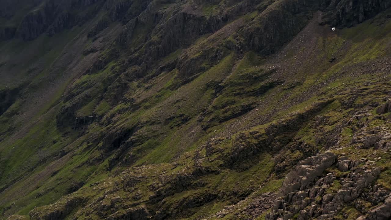 una toma panorámica que revela la ladera de una montaña rocosa en las tierras altas de escocia | el valle perdido, glencoe, escocia | filmado en 4k a 30 fps
