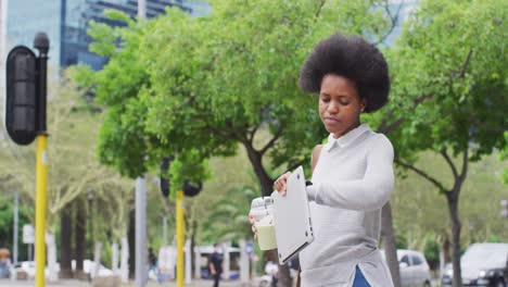 Mujer-De-Negocios-Afroamericana-Sosteniendo-Una-Computadora-Portátil-Y-Revisando-El-Reloj-Inteligente