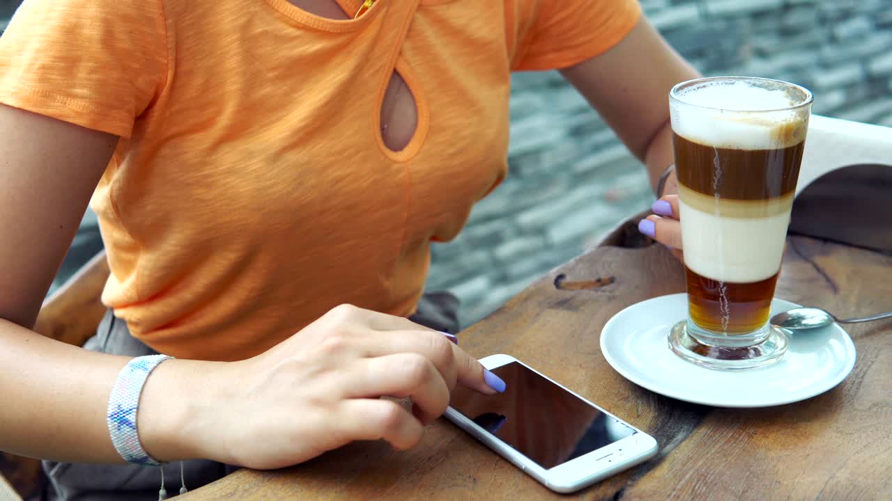 cerrar las manos usando teléfonos inteligentes dispositivo de pantalla táctil digital mientras bebe café