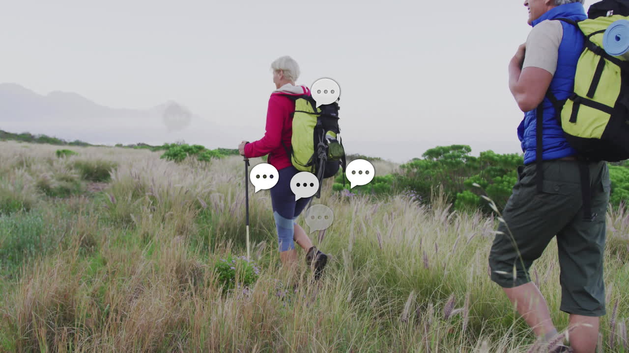mature hikers trekking through grassy hills, with animated fitness chart showing heart rate