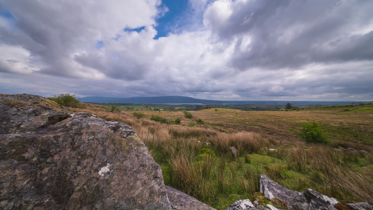 Panorama motion time lapse of rural landscape with rocky foreground and hills and lake in the distance on a spring sunny cloudy day in Arigna mountains in county Leitrim in Ireland