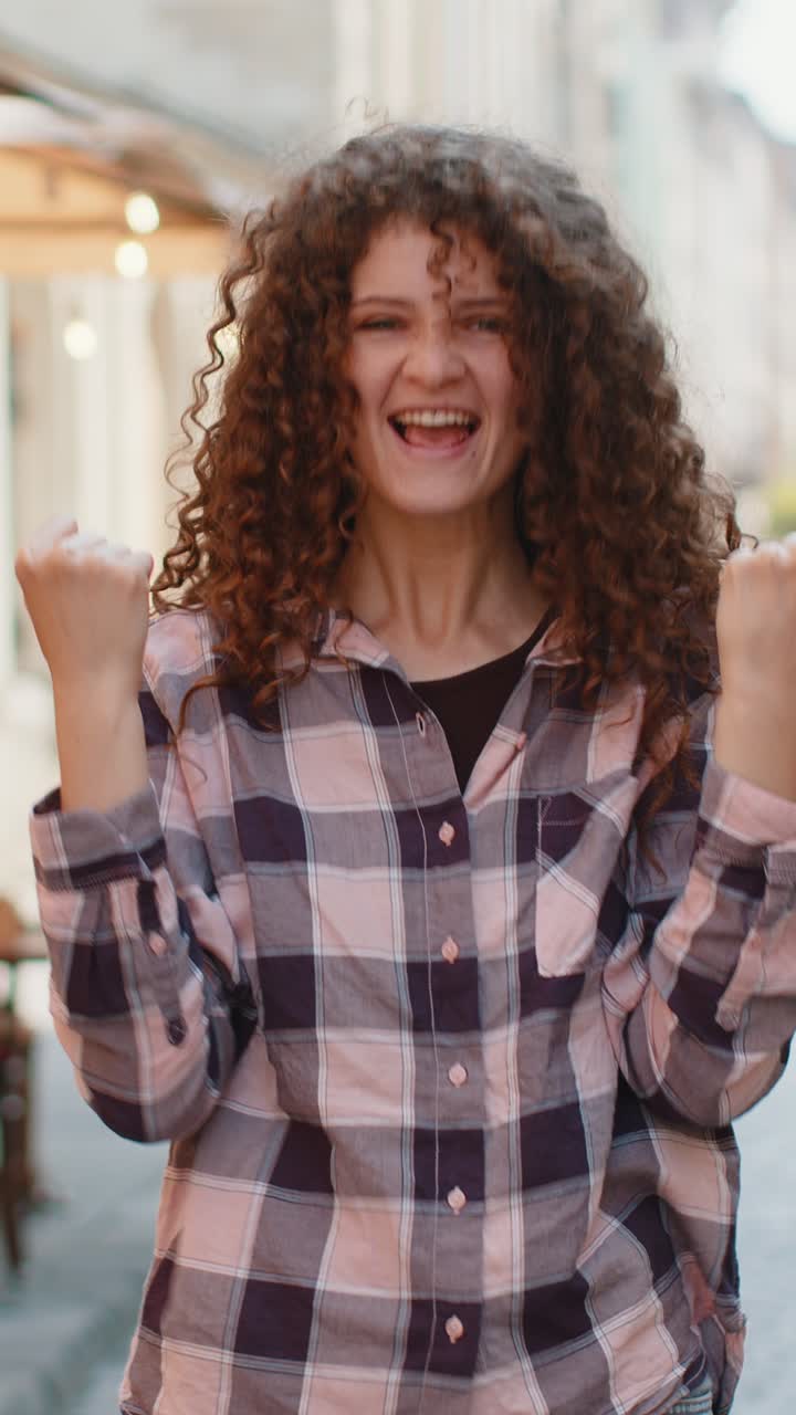 Giovane donna che grida festeggiando il successo il traguardo del traguardo della vittoria buone notizie di vittoria per la strada della città