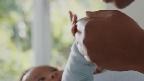 close up mother holding baby hand touching fingers nurturing newborn caring for infant at home enjoying motherhood