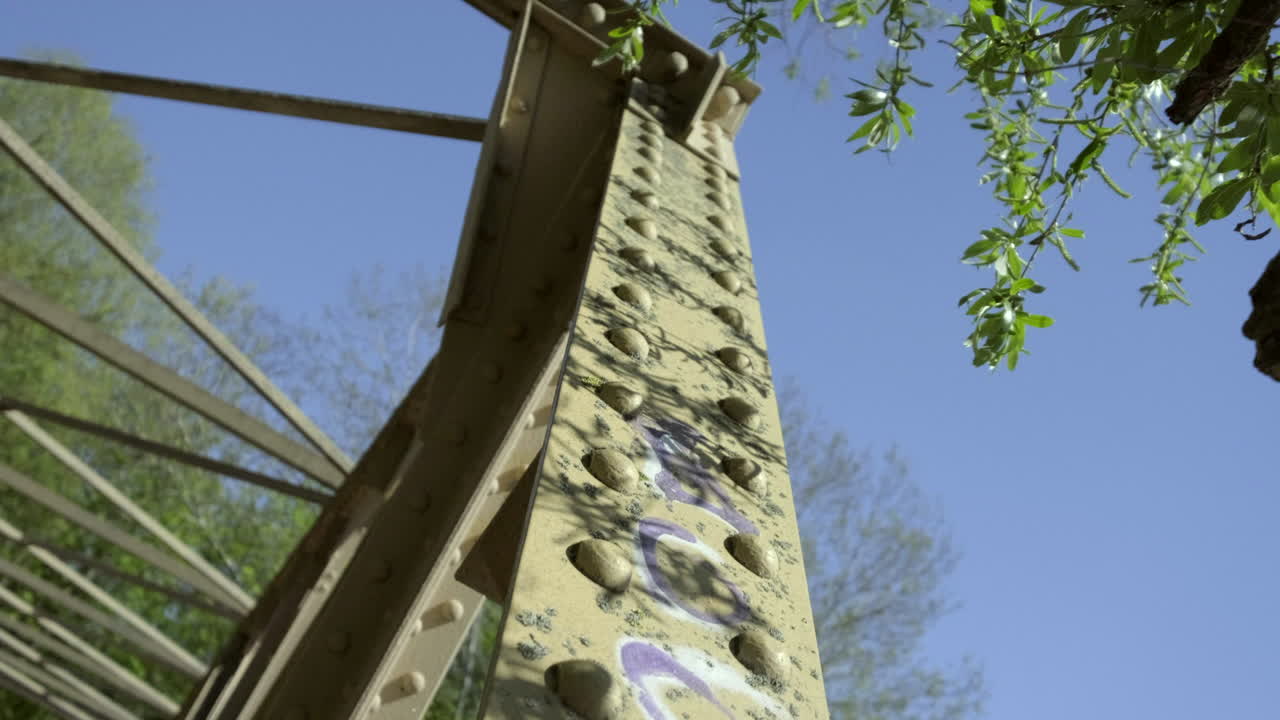 A slider move across the bridge posts. Graffitys are covering the bridge.