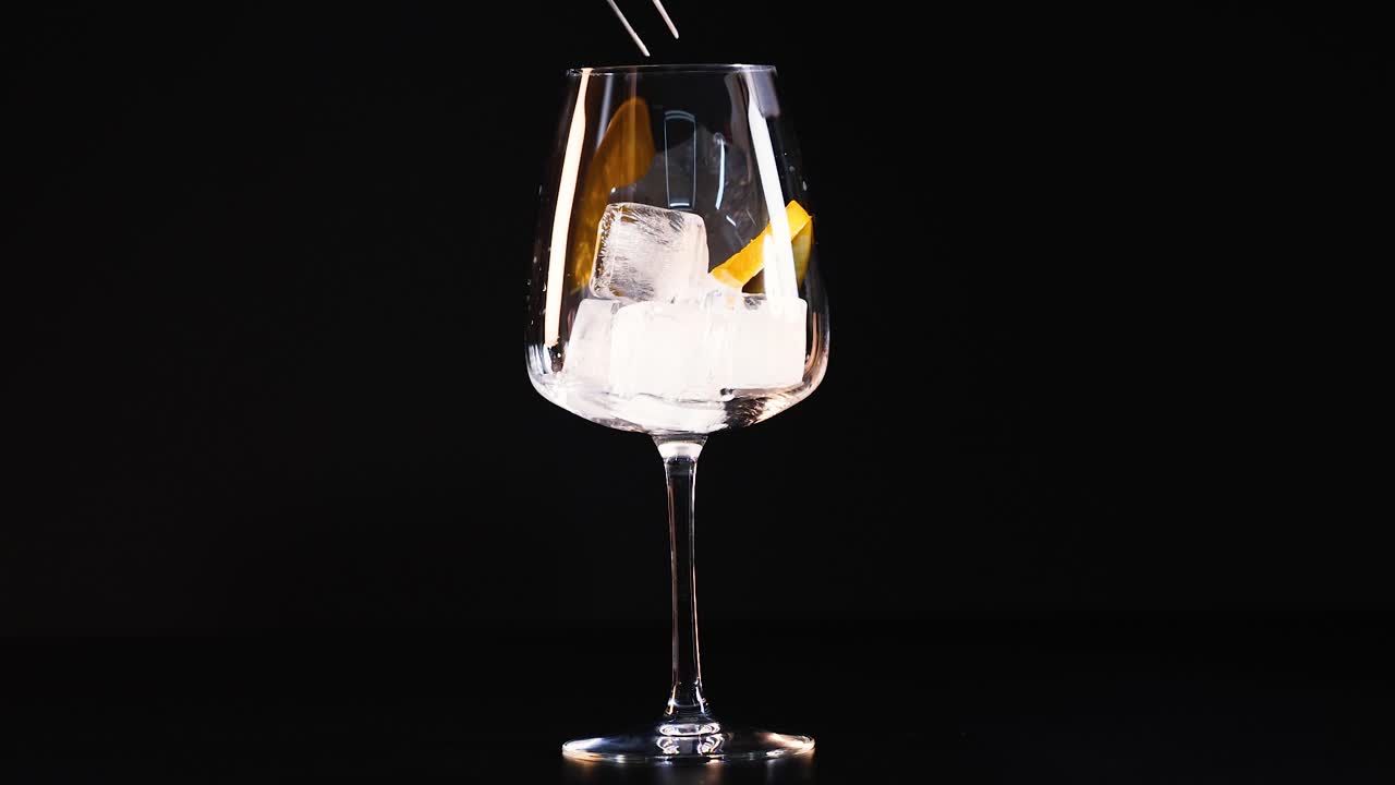 Bicchiere con ghiaccio e fetta d'arancia, mescolato