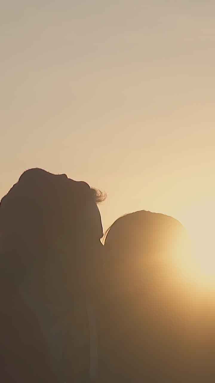 happy young couple rests with friends in tourist camp on meadow in autumn evening at back sunset light slow motion