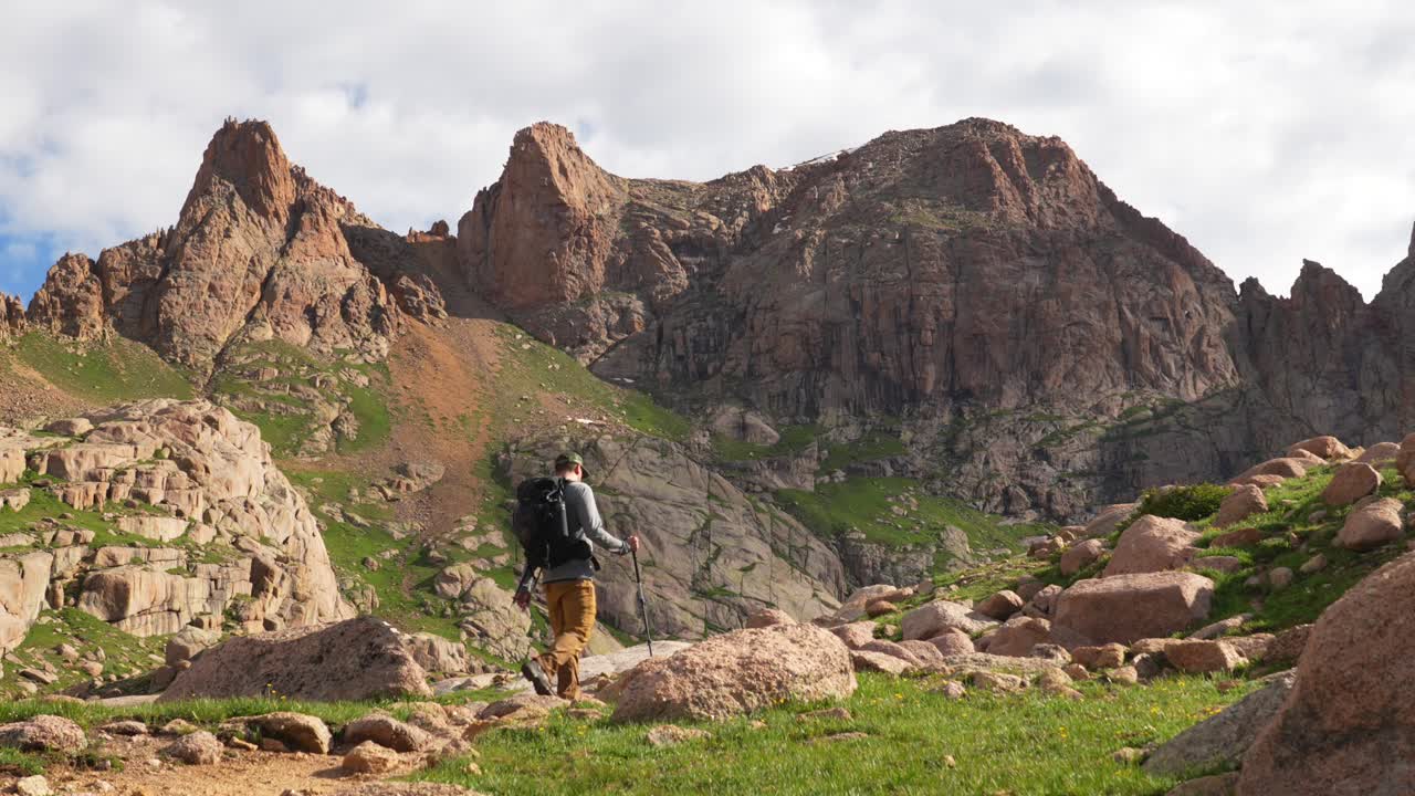 Hiker traversing a rocky mountain landscape