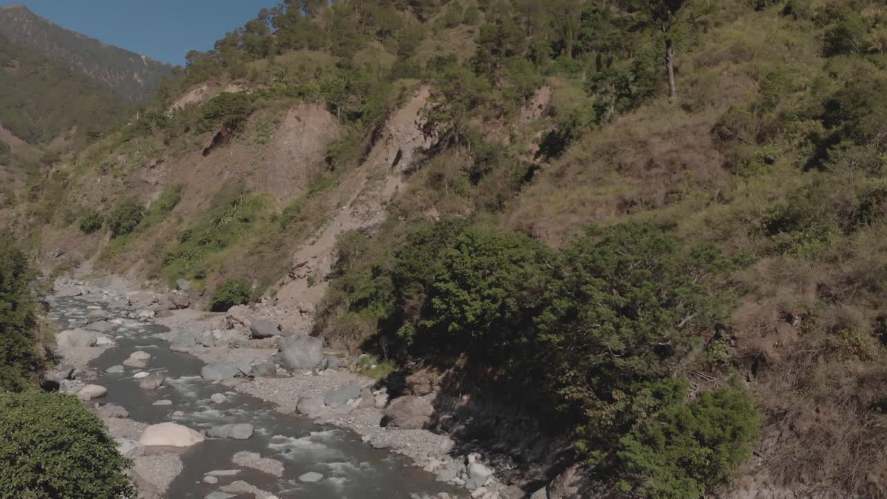 Mountain river flowing in mountain valley surrounded green trees rocks still aerial wide angle Kabayan Benguet Philippines