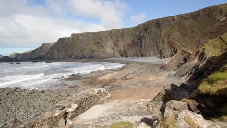 toma extra ancha de eye cove con los acantilados cayendo en el mar en la distancia, tomada en el muelle de hartland, stoke, hartland, bideford