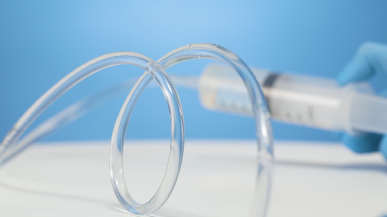 가까운 의료 튜브와 투명한 물과 같은 액체, 흐릿한 주사기