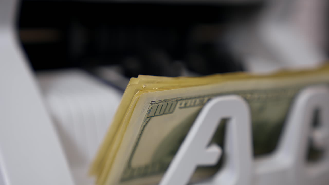 Cash money counting equipment. Currency counting machine counting dollar banknotes. Bank automatic equipment for counting paper money. Close-up.