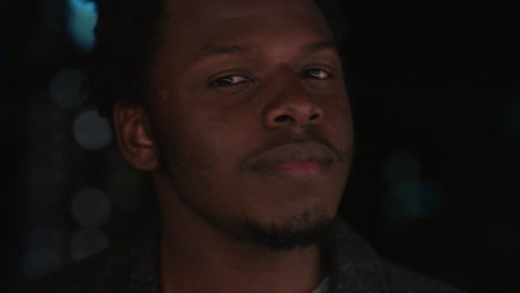 portrait handsome african american man on rooftop at night drinking alcohol smiling happy enjoying urban nightlife with bokeh city lights in background