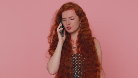 redhead young woman having pleasant mobile conversation using smartphone with friends, telling news