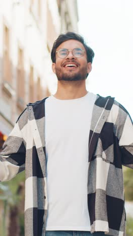 joven turista indio meditando respira profundamente con el gesto mudra mientras está de pie en la calle de la ciudad