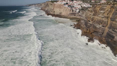 majestic town of azenhas do mar on rocky cliff side in portugal, sea hitting coast