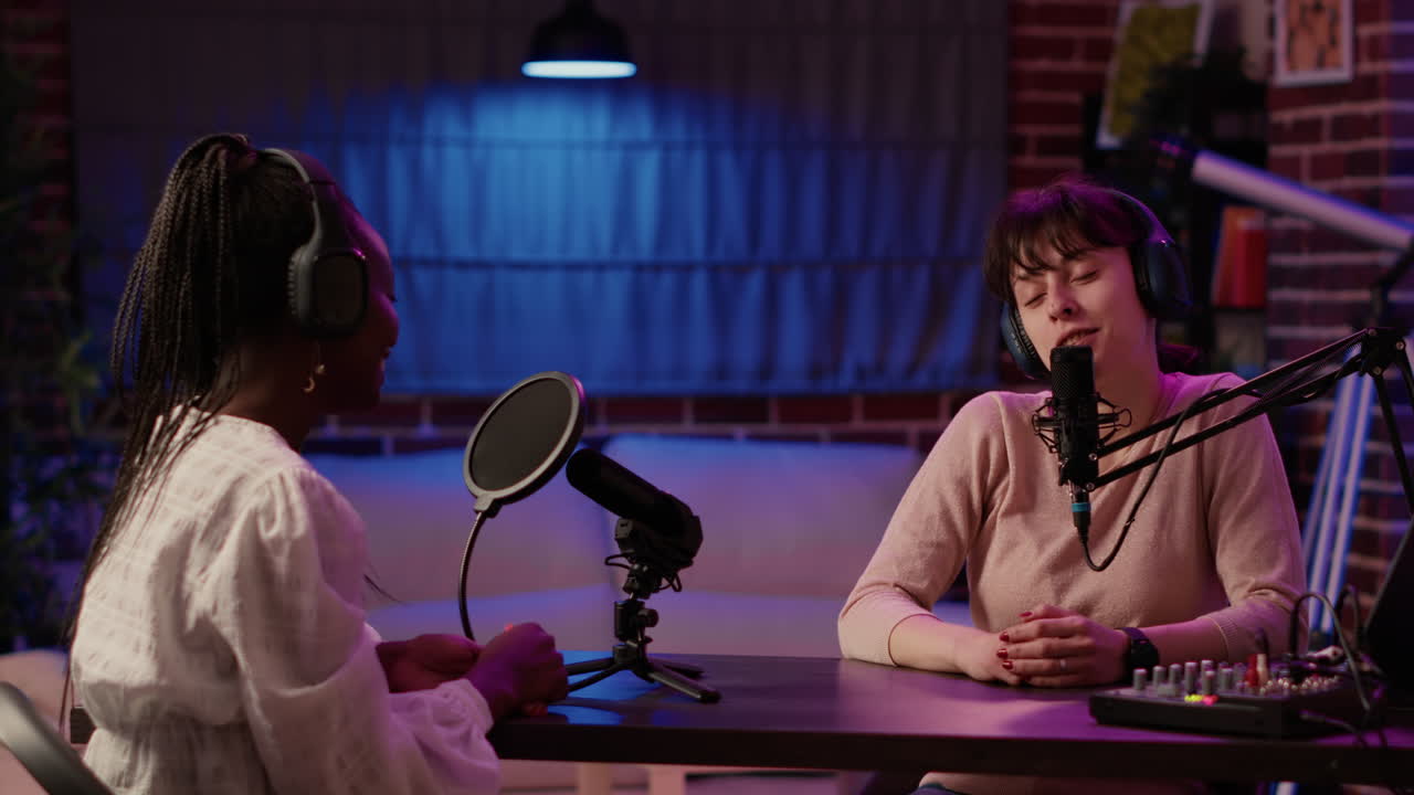 Online radio host doing high five hand gesture with african american influencer during live podcast in living room