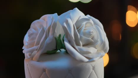 white roses made of fondant that decorate a cake for a wedding celebration