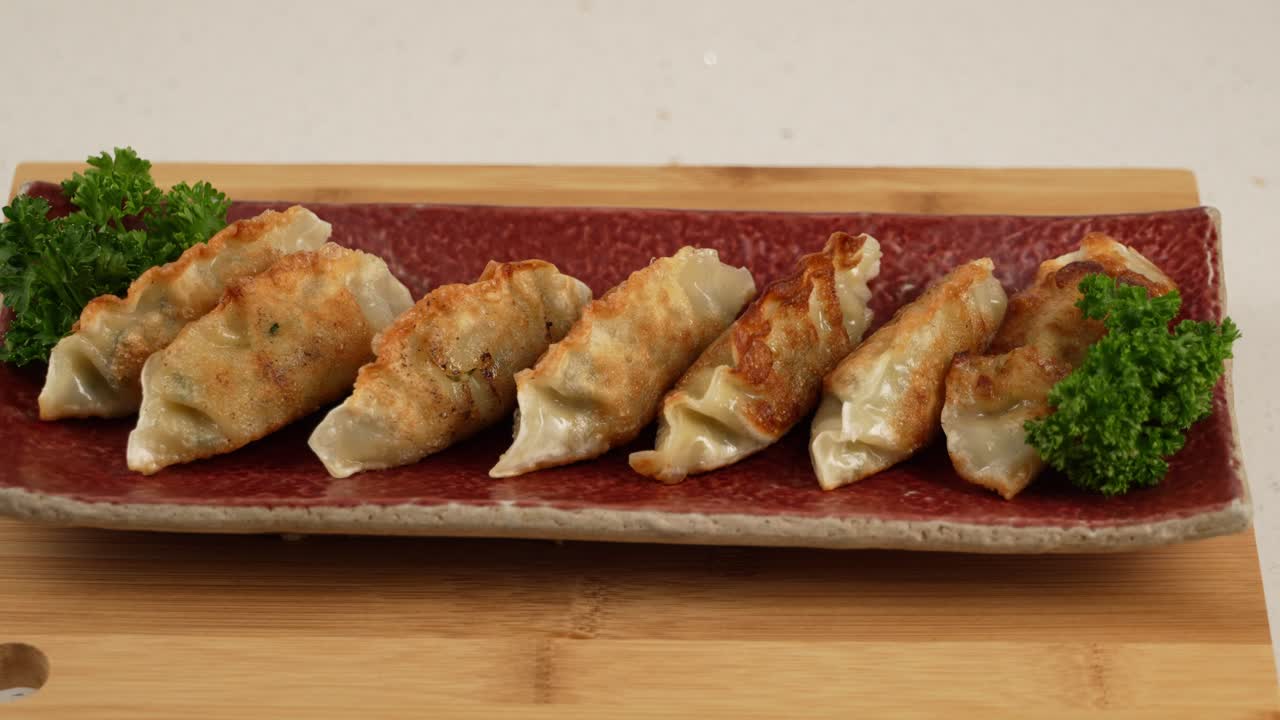 Crispy golden fried dumplings with a juicy filling, perfect with dipping sauce. 바삭하게 튀겨진 군만두, 육즙 가득한 속이 매력적인 한 입.