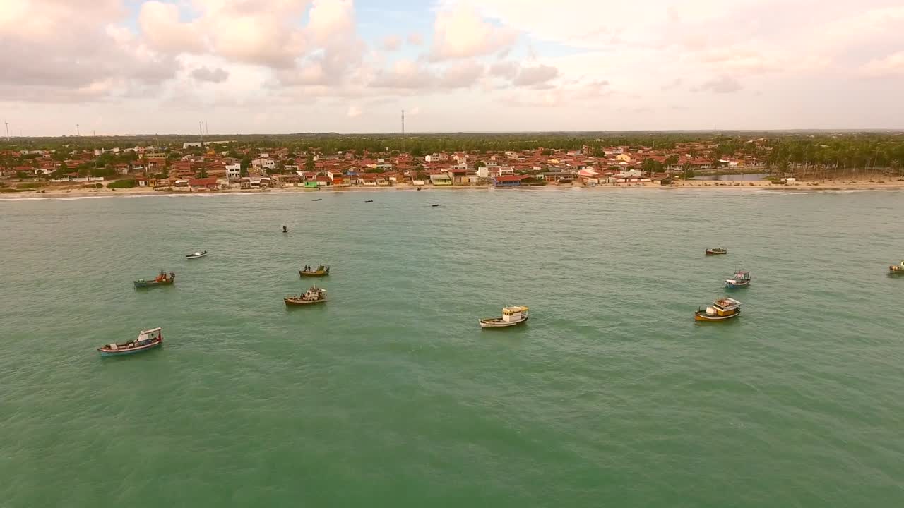 una vista aérea de un barco de pesca tradicional amarrado en el mar turquesa de río del fuego, brasil.