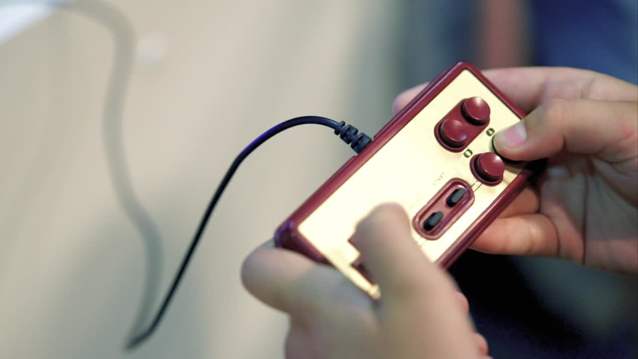 persona che gioca con un controller di videogioco retro