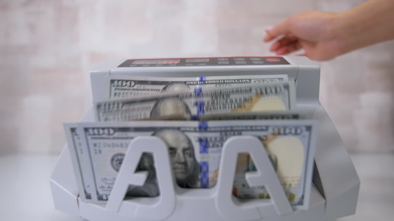 Currency counting machine counts dollar bills. Money counting equipment for paper money calculation. Currency exchange of one hundred dollars. Front view.