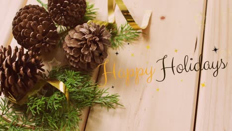 animation of happy holidays text over christmas pine cones