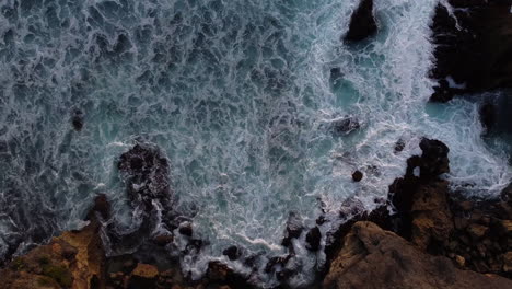 Vista-De-Pájaro-Del-Océano-Rompiendo-En-La-Orilla-En-Uluwatu,-Bali