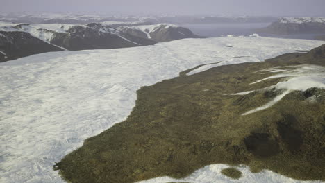 Glacier landscape shows contrast between ice and rocky terrain in remote area