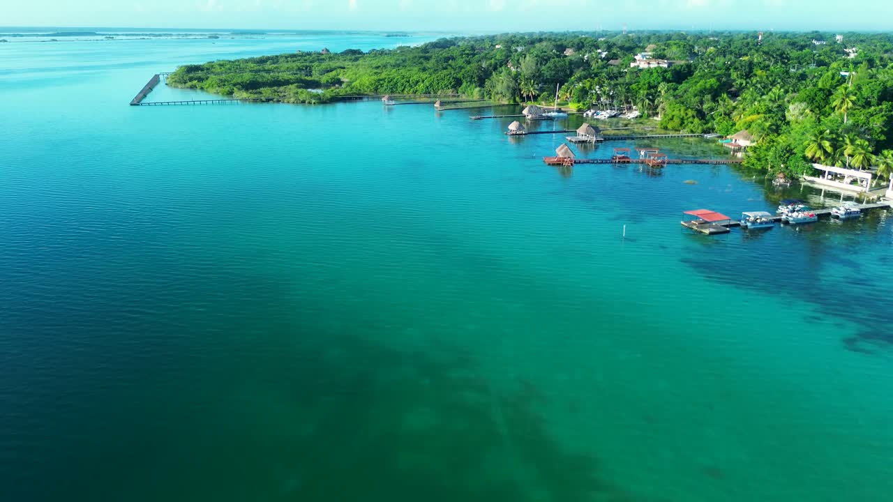 Drone aerial landscape of Bacalar lagoon lake inlet with jetty pier boardwalk wharf suburbs town rainforest in Quintana Roo Mexico travel holidays tropical paradise